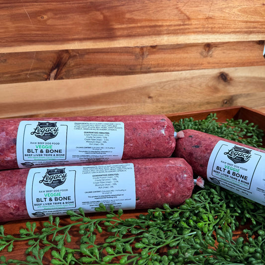 Packaged raw BLT & bone rolls in tray with scattered green herbs, pink meat