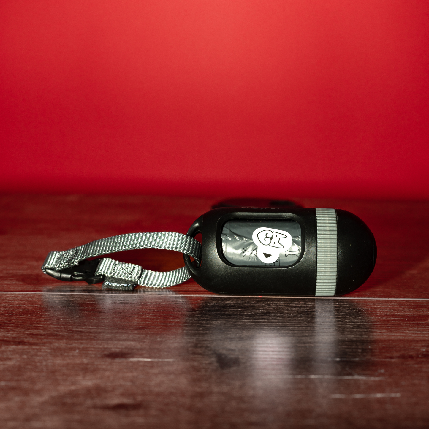 Black dog collar with metal clip on a red background