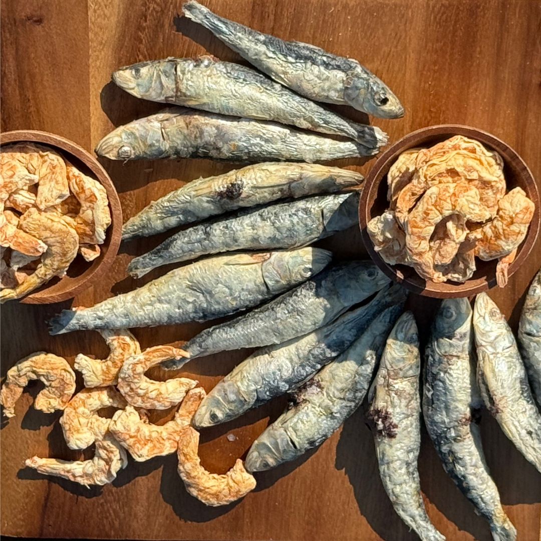 Freeze dried sardines and shrimp on wood counter and in bowls