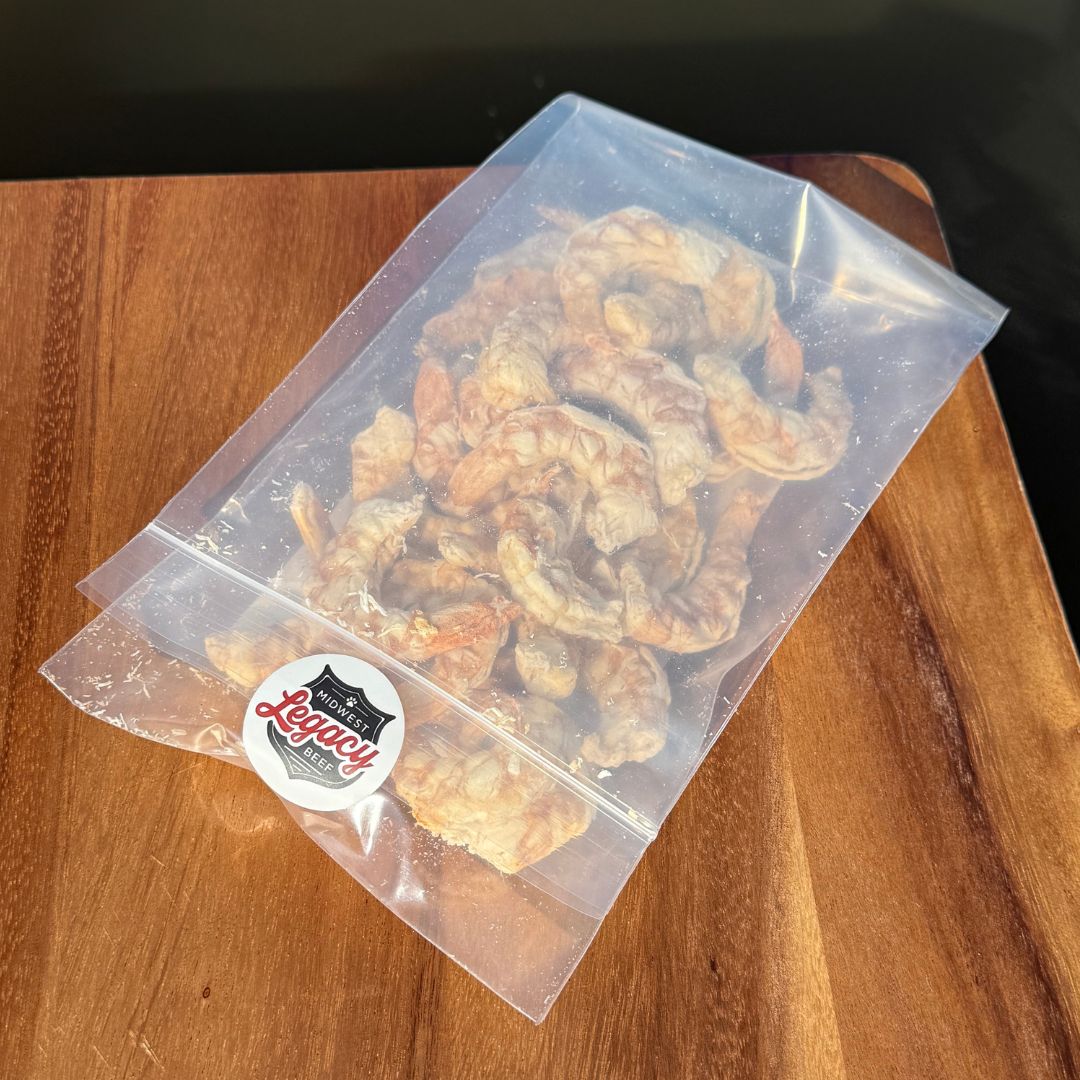 Clear plastic packaging with freeze dried shrimp on a wooden surface