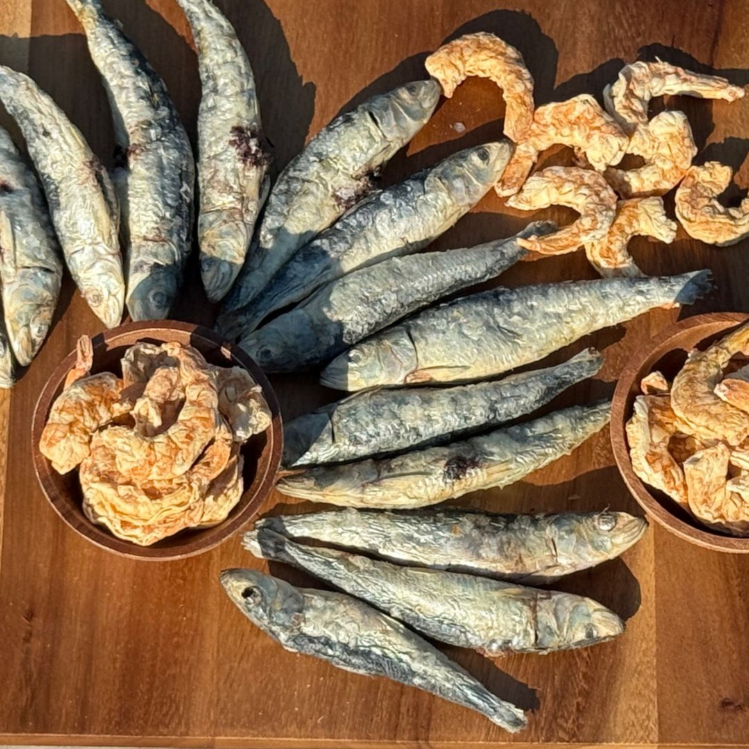 Freeze dried sardines and shrimp on a wooden surface and in bowls