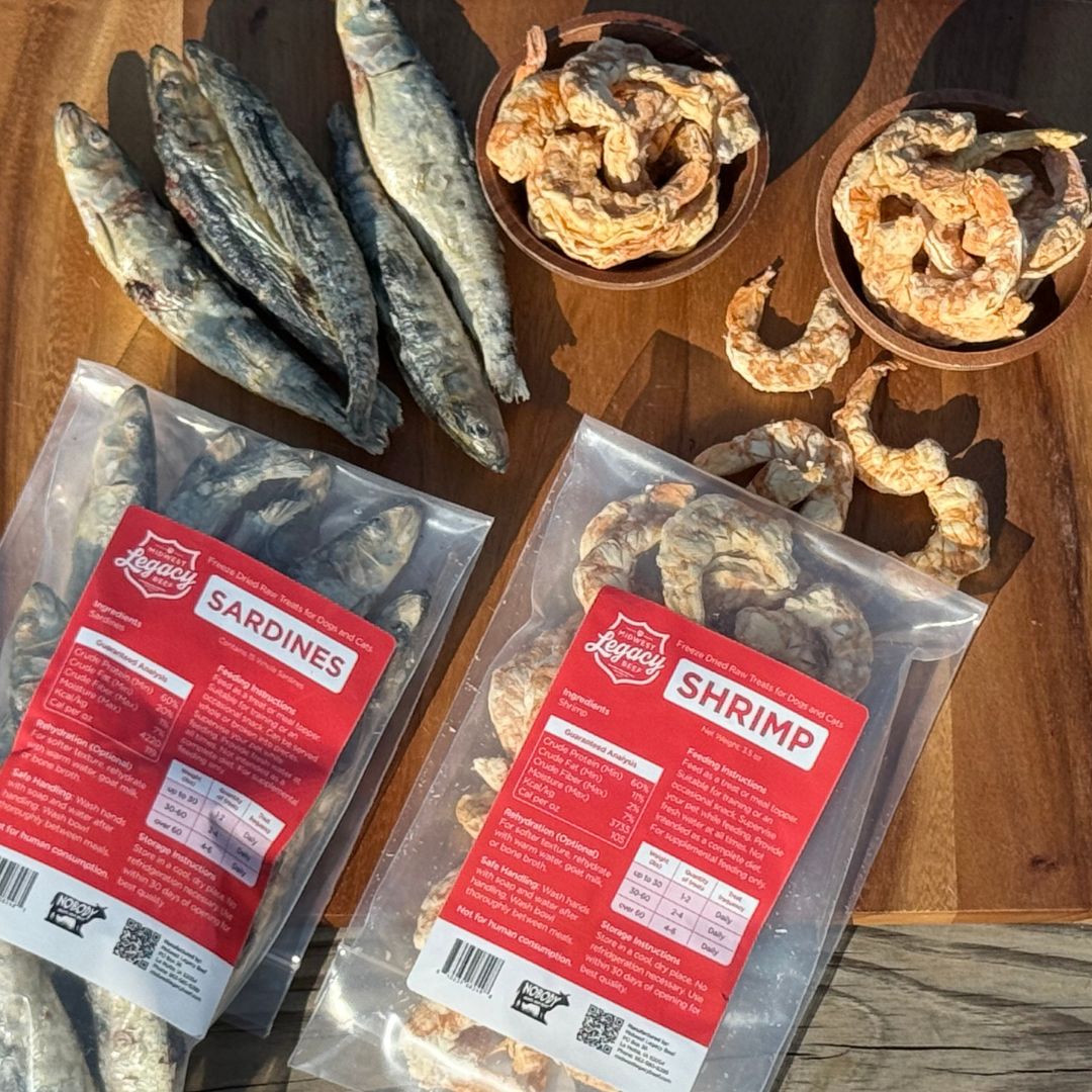 Packaged freeze dried sardines and shrimp on a wooden surface with dried shrimp in bowls.