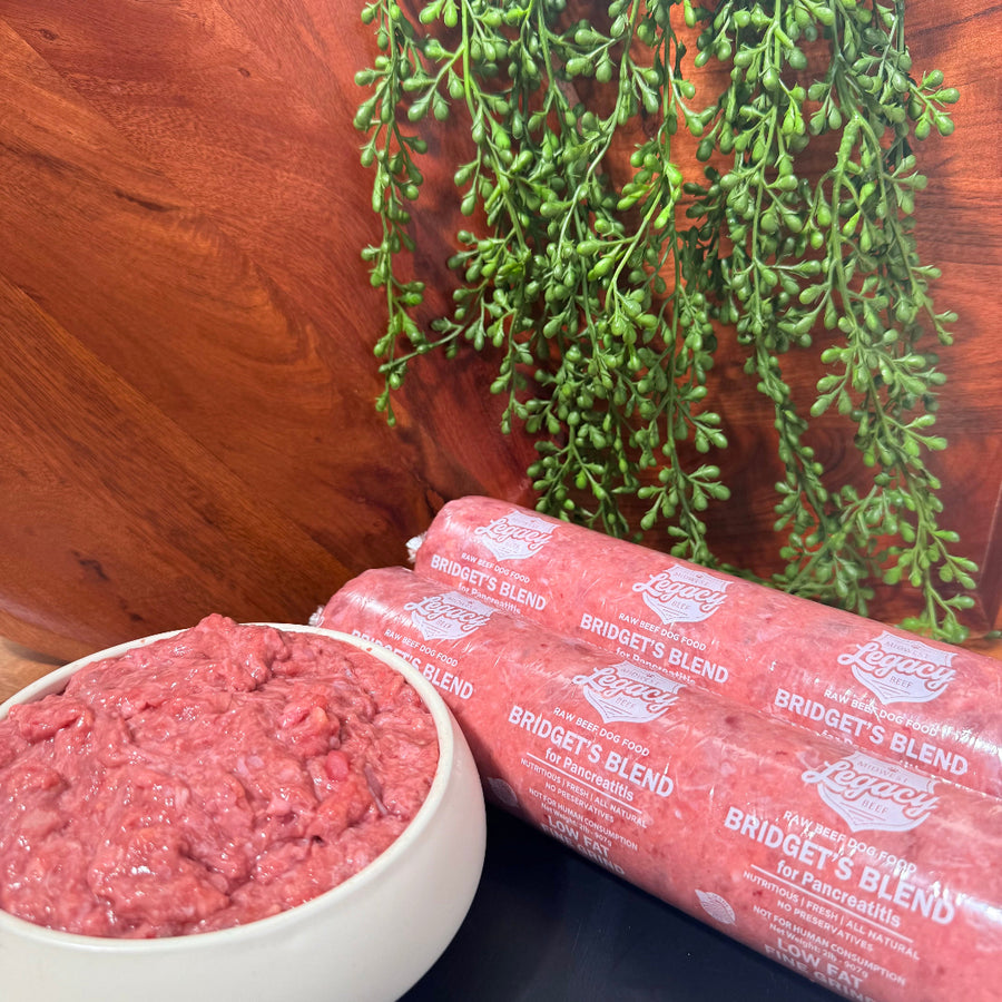 Packaged pink ground dog food and bowl on a wooden surface