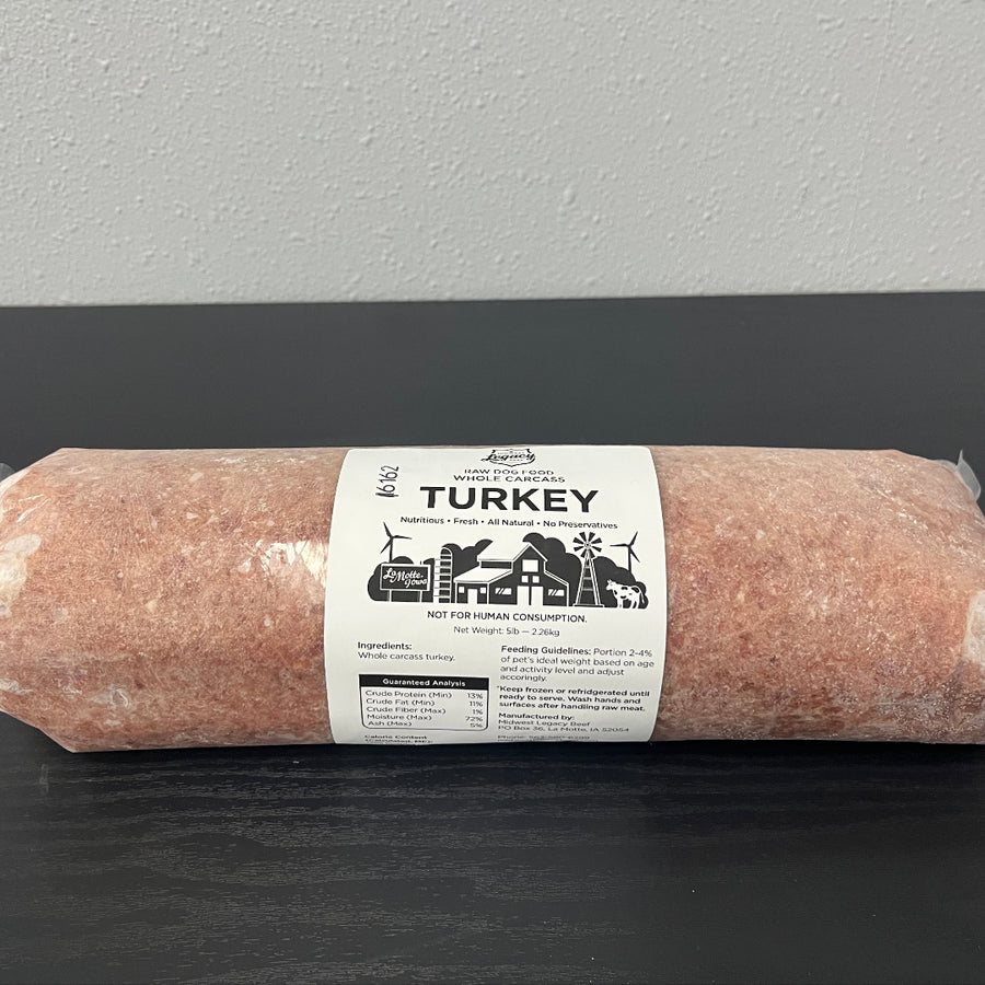 Wrapped raw turkey log with label on a dark tray