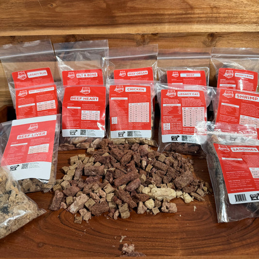 Freeze-dried pet food sample pack with multiple pouches and a mound of chunks.