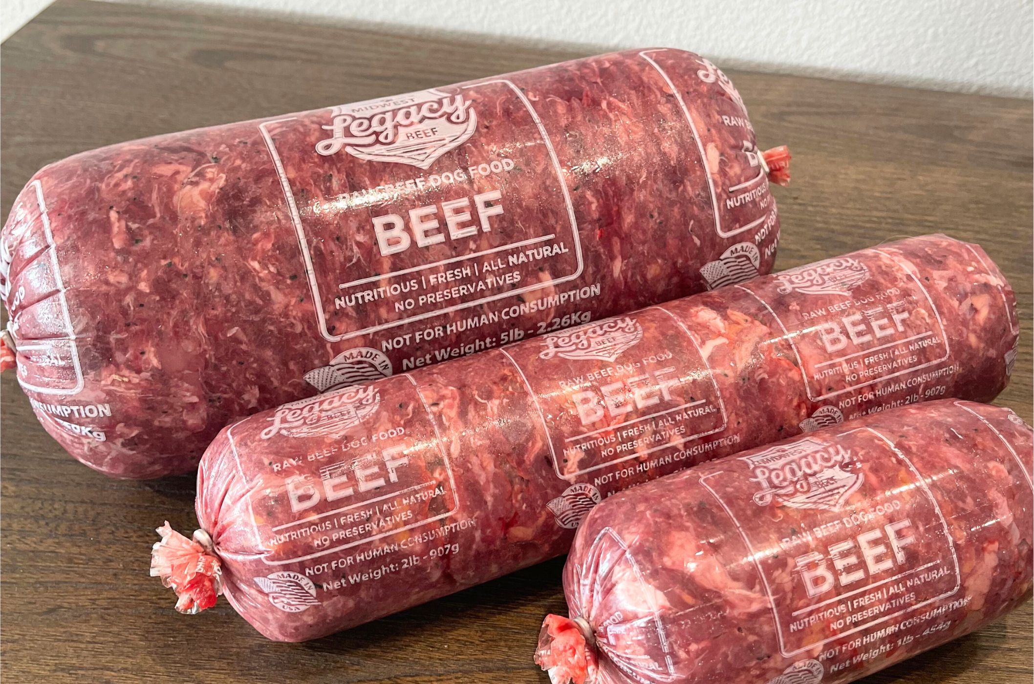 midwest dog food rolls of raw beef in 5, 2 and 1 pound chubs on wooden table